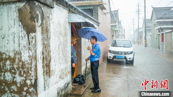 孙益海冒雨走访村民。 公安部供图 孙益海冒雨走访村民。 公安部供图